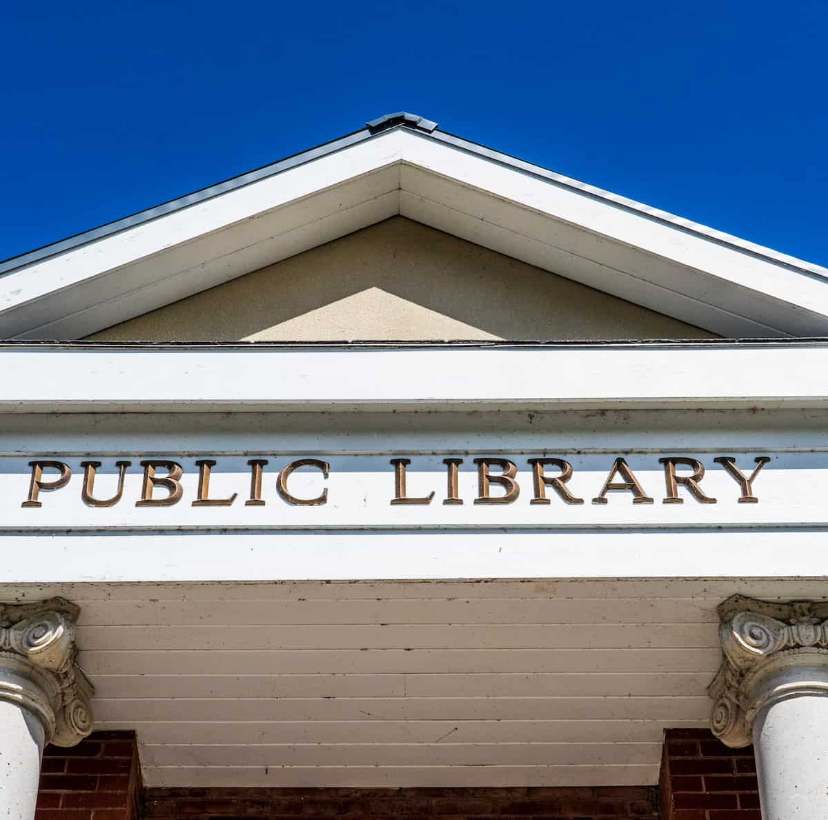 photo of public library sign and roof against blue sky representing free HR resources