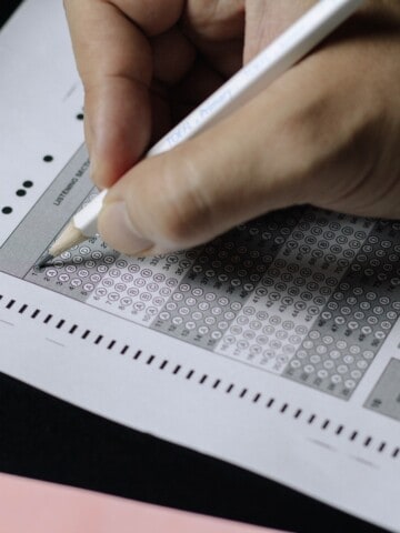 Hand marking Scantron circles symbolizing a recruiting assessment